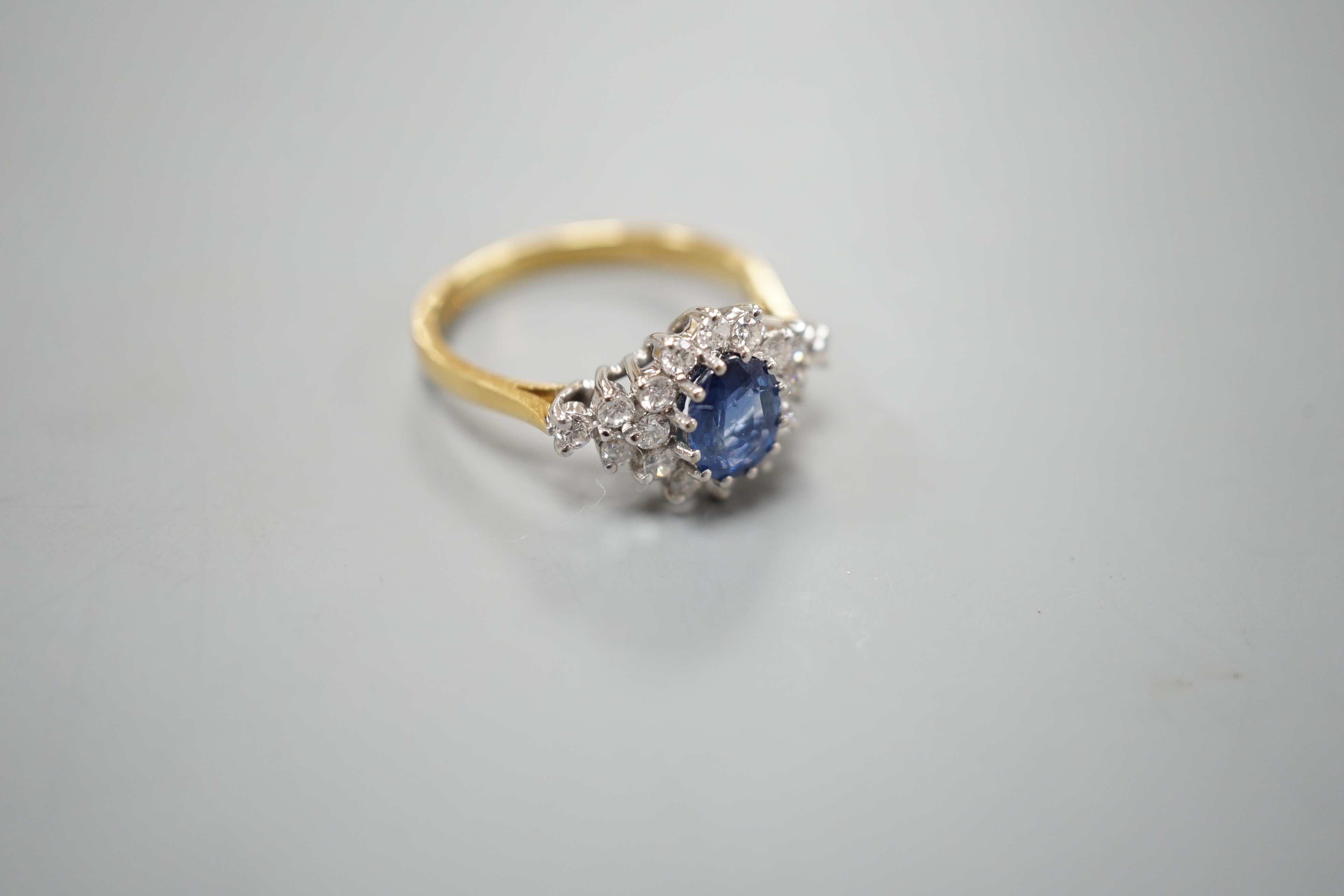 A modern 18ct gold, sapphire and diamond set elliptical shaped cluster dress ring, size N, gross weight 3.5 grams